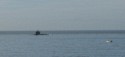 We see a submarine entering Lisbon harbor